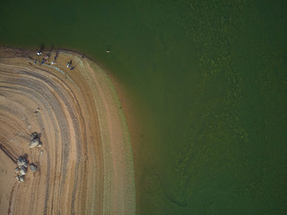 Aerial view of the Valdecañas reservoir, with green water from the algae and natural lines of the...