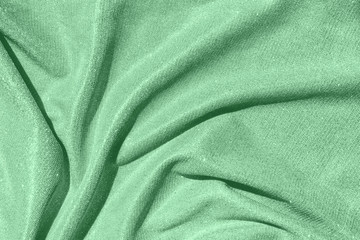 Trendy mint colored Background of draped fabric with silver lurex thread. Beautiful fashionable fabric with a shiny thread for making clothes. Textile background texture.