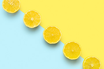 lemon halves in row on pastel yellow and blue background. Minimal summer concept. Flat lay, absrtact, trendy pattern.