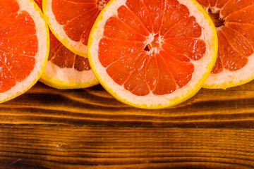 Sliced juicy grapefruit on a wooden table. Top view