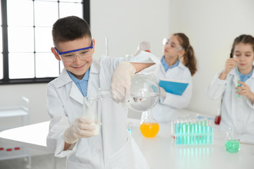 Smart schoolboy making experiment in chemistry class