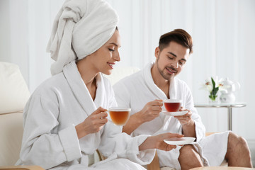 Obraz na płótnie Canvas Romantic young couple with tea in spa salon