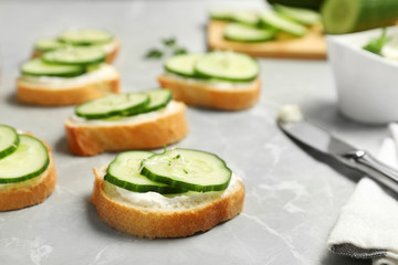 Traditional English cucumber sandwiches on grey table. Space for text