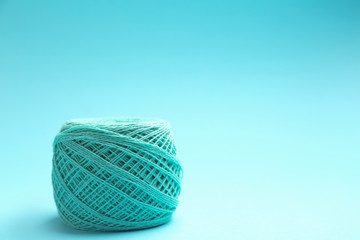 Clew of knitting threads on color background, space for text. Sewing stuff