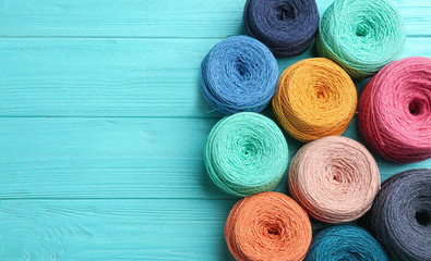 Colorful clews of threads on wooden table, top view. Space for text