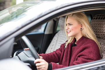Fototapeta na wymiar Beautiful angry woman honking in her car while driving