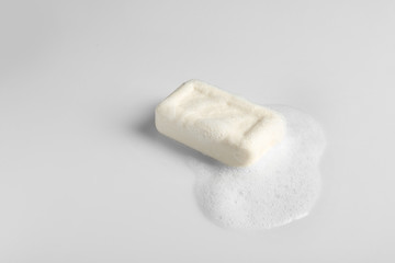 Soap bar and foam on white background