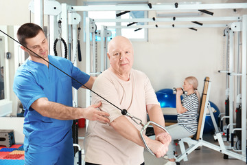Patient exercising under physiotherapist supervision in rehabilitation center