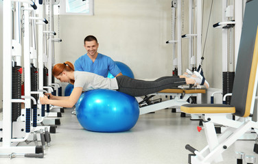 Patient exercising under physiotherapist supervision in rehabilitation center