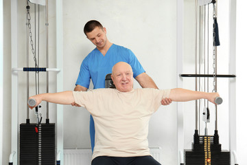 Patient exercising under physiotherapist supervision in rehabilitation center