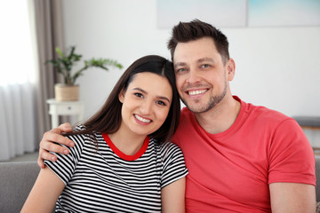 Obraz premium Happy couple hugging and smiling at home
