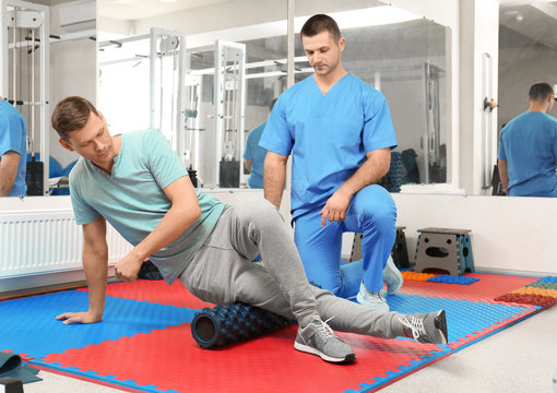 Patient exercising under physiotherapist supervision in rehabilitation center