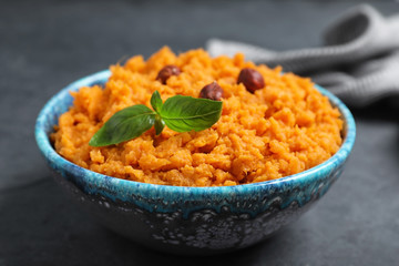 Bowl with mashed sweet potatoes on grey table