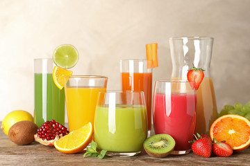 Glassware with different juices and fresh fruits on table