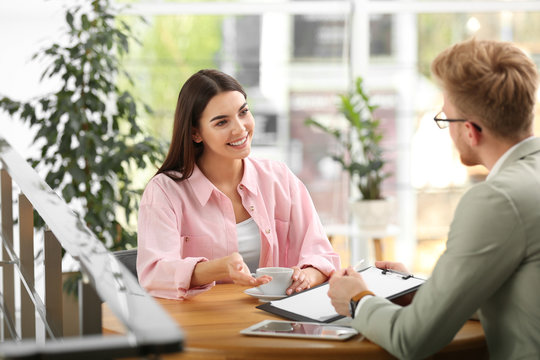 Insurance Agent Working With Young Woman In Office