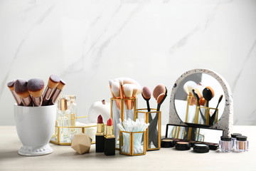 Set of makeup products and brushes on table