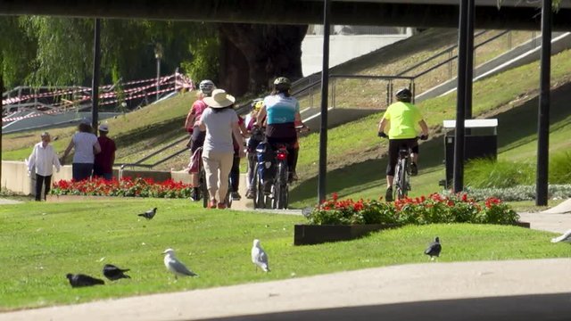 People walking and riding in a busy park