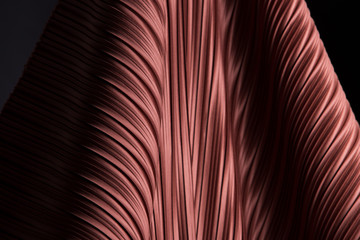 Pleat Fabric in long line drape with shadow, pleated style of textile pattern in red burgundy color put in layer design wave wallpaper, studio lighting close up background image