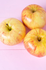 Set of red and yellow apples on pink background