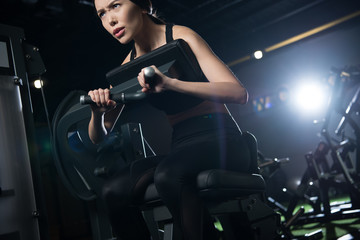 Fototapeta na wymiar low angle view of sportswoman exercising on training apparatus in gym