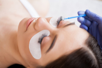 Eyelashes extensions. Fake Eyelashes. Eyelash Extension Procedure. Professional stylist lengthening...