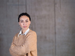 portrait of casual businesswoman in front of a concrete wall