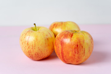 Set of red and yellow apples on pink background