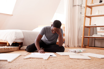 Frustrated Man In New Home Putting Together Self Assembly Furniture