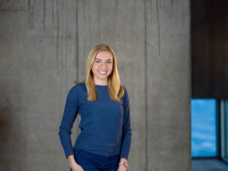 portrait of casual businesswoman in front of a concrete wall