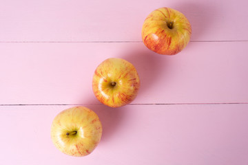 Set of red and yellow apples on pink background