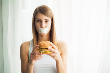 Diet. Young woman preventing her to eat junk food. Healthy eating concept