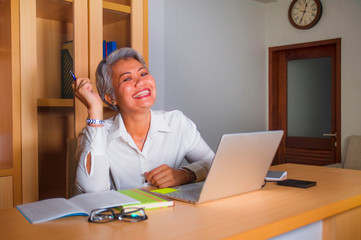 corporate job lifestyle portrait of happy and successful attractive middle aged Asian woman working...