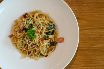 Top view of Delicious spicy spaghetti with bacon, dried chilli, basil and garlic with fork and spoon prepare side dish