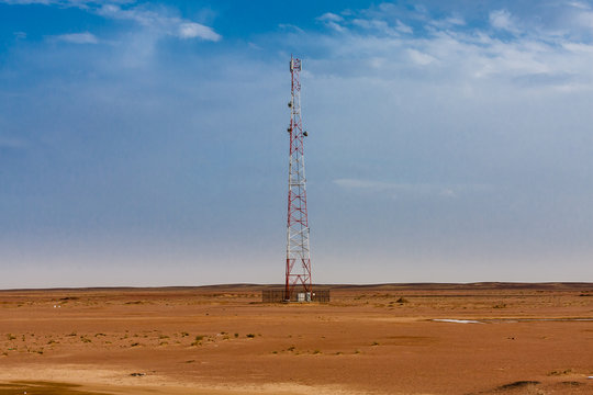 A mobile tower in the desert near the paved road in Saudi Arabia