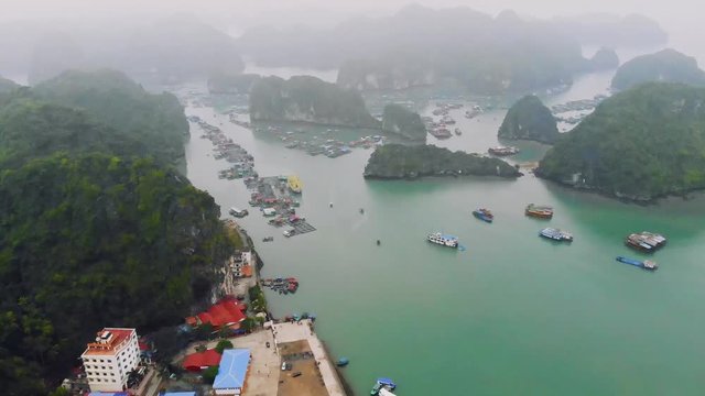 Aerial view of floating villages around Cat Ba islands. Cat Ba is the largest of the 366 islands, which make up the southeastern edge of Ha Long Bay in Vietnam. 4K move drone