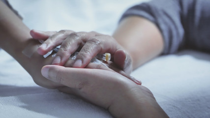 Mother holding hand of his son sick bed in the hospital. Touch the hand. care encouragement