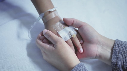 Mother holding hand of his son sick bed in the hospital. Touch the hand. care encouragement