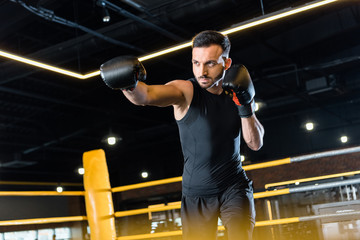 Fototapeta na wymiar low angle view of handsome bearded man boxing in gym