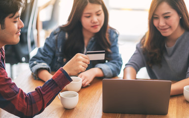 Three young asian people use credit card for purchasing and shopping online