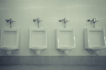 Row of white urinals in men toilet