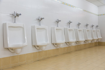 Row of white urinals in men toilet