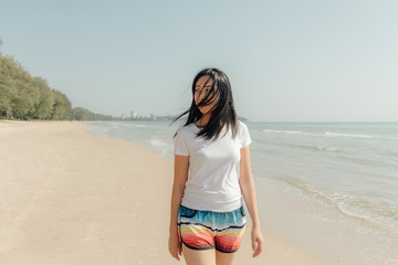 Woman walk on the beach with sunny sun of summer.