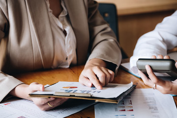 Close up Businessman and partner using calculator for calaulating finance, tax, accounting, statistics and analytic research concept