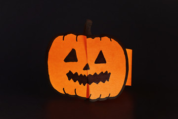 Fototapeta premium Diy Halloween paper bracelet pumpkin on black background. Gift idea, decor Halloween