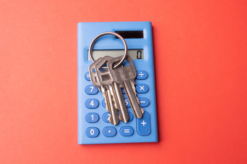 Keys on mini blue calculator isolated, home, security, bank loan, financial concept, future family planning, close up selective focus, copy space.