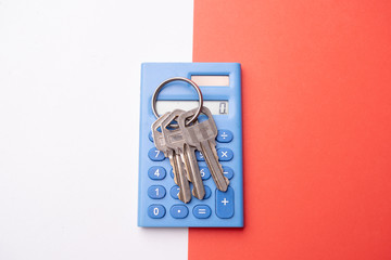 Keys on mini blue calculator isolated, home, security, bank loan, financial concept, future family planning, close up selective focus, copy space.