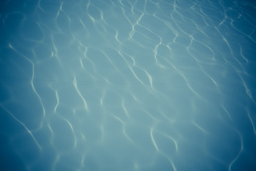 Blue pool water with sun reflections