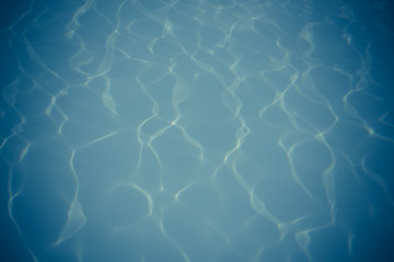 Blue pool water with sun reflections