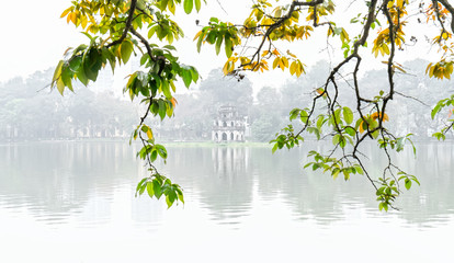 Obraz premium Tree in bud at Hoan Kiem lake in Hanoi Capital, Vietnam with Turtle Tower. This is an ancient architecture preserved to this day