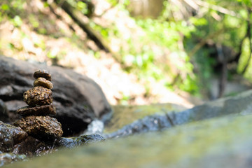 Four stones are arranged vertically and have flowing through the forest.